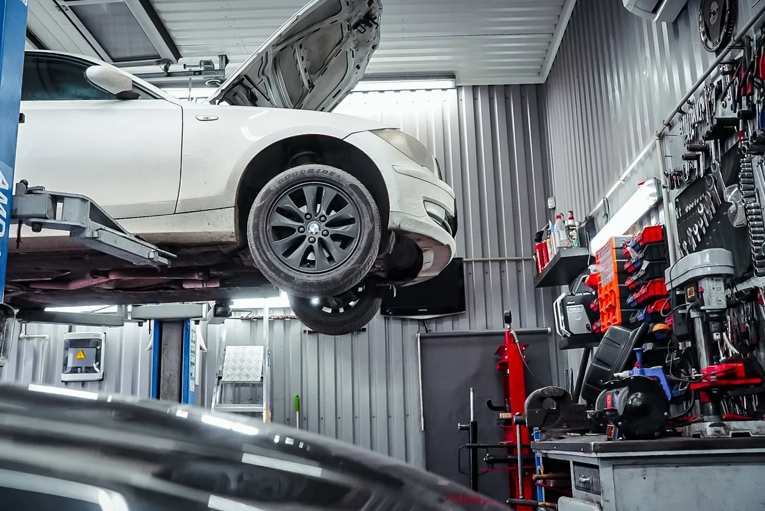 Meistras atlieka automobilio diagnostiką po apačia